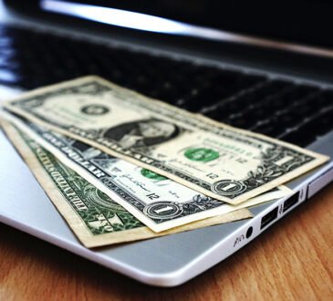 Digital icons representing online earning methods on a laptop screen.