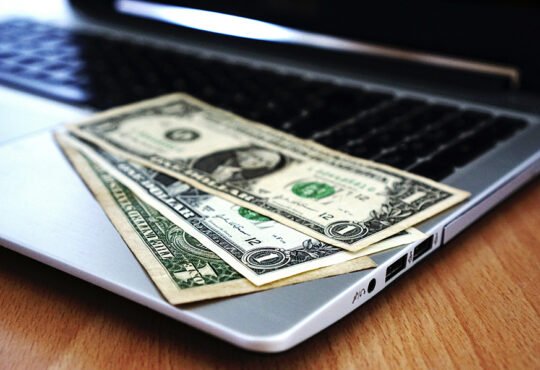 Digital icons representing online earning methods on a laptop screen.